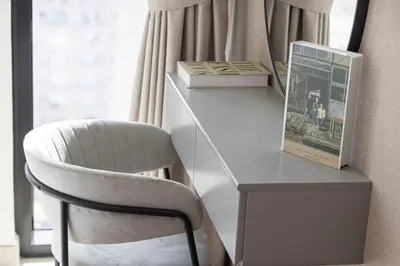 a white desk with a chair and a book at Private Pool! Exceptional 2 Bedroom! Brand New Building with Pool and Gym! in Dubai