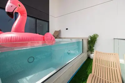 a swimming pool with a pink inflatable flamingo next to a bench at Private Pool! Exceptional 2 Bedroom! Brand New Building with Pool and Gym! in Dubai