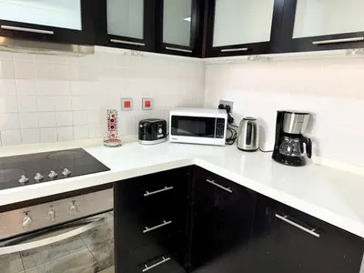 a kitchen with a counter top with a microwave at Space, Style & Sunshine 2bedroom in Dubai