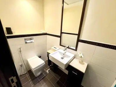 a bathroom with a sink and a toilet and a mirror at Space, Style & Sunshine 2bedroom in Dubai