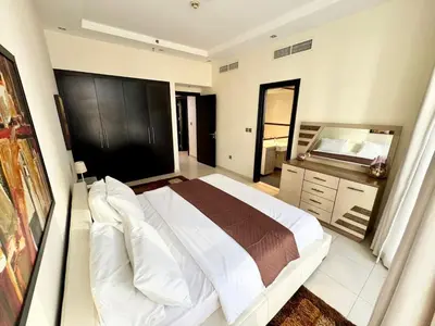 a bedroom with a large bed and a dresser at Space, Style & Sunshine 2bedroom in Dubai