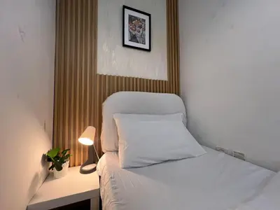 a bedroom with a bed with a white pillow and a lamp at Minimalist Room In Al Barsha 1 Near Mall of Emirates in Dubai