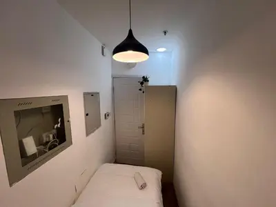 a small room with a bed and a pendant light at Elite Single Suite Room Partition In Tecom in Dubai