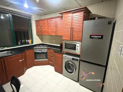 a kitchen with a refrigerator and a dishwasher at Elite Single Suite Room Partition In Tecom in Dubai