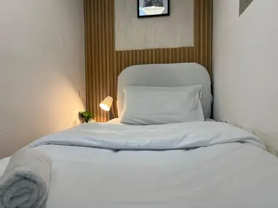 a white bed in a room with a pillow at Elite Single Suite Room Partition In Tecom in Dubai