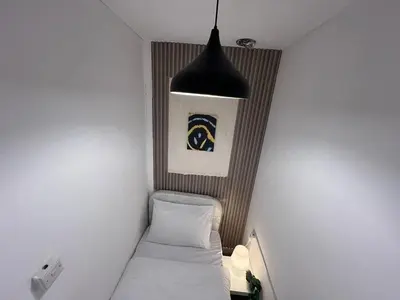 a small room with a bed and a pendant light at Deluxe solo Room In Barsha Heights Tecom in Dubai