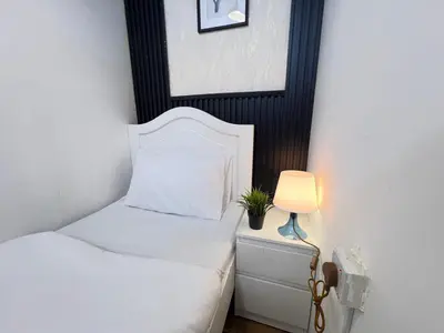 a small bedroom with a bed and a lamp at Comfort Nock Partition Room Near Mall Of emirates in Dubai