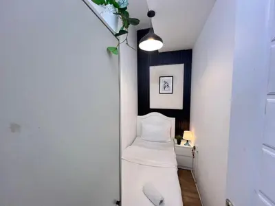 a hallway with a white bed in a room at Comfort Nock Partition Room Near Mall Of emirates in Dubai