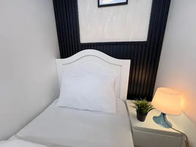 a white bed with a white pillow and a lamp at Comfort Nock Partition Room Near Mall Of emirates in Dubai