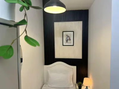 a bedroom with a white bed and a black wall at Comfort Nock Partition Room Near Mall Of emirates in Dubai