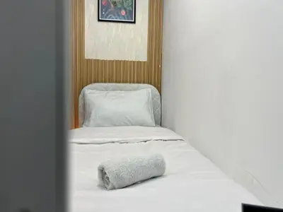 a white bed with a pillow on top of it at Solo space Partition room In Barsha Heights Tecom in Dubai