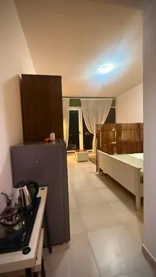 a kitchen with a stove and a bed in a room at Studio-Like Private Bedroom with Balcony & Private Washroom in JLT in Dubai
