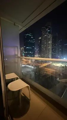 a room with a view of a city at night at Studio-Like Private Bedroom with Balcony & Private Washroom in JLT in Dubai