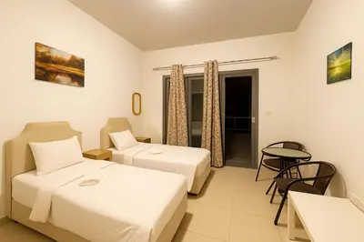 a hotel room with two beds and a table at The S Royal Marina Boutique Stay For Ladies And Families Only in Dubai