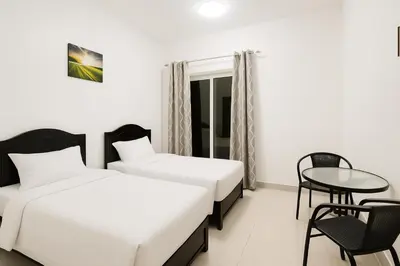 a hotel room with two beds and a table and chairs at The S Royal Marina Boutique Stay For Ladies And Families Only in Dubai