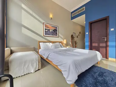 a bedroom with a large bed and a chair at Efficiancy studio 6mins walk to metro Near DWTC in Dubai