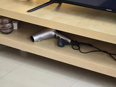 a hair dryer sitting on a shelf next to a tv at Efficiancy studio 6mins walk to metro Near DWTC in Dubai