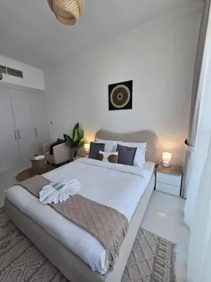 a bedroom with a large white bed in a room at Modern DAMAC Hills Studio with Balcony, Gym & Pool in Dubai