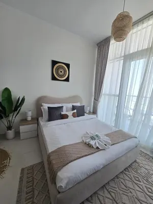a bedroom with a large bed and a large window at Modern DAMAC Hills Studio with Balcony, Gym & Pool in Dubai