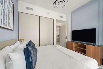 a bedroom with a bed and a flat screen tv at Silkhaus Seaside Bliss 1BDR in Marina Vista in Dubai