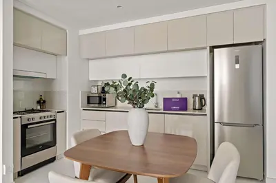 a kitchen with a wooden table with a vase on it at Silkhaus Seaside Bliss 1BDR in Marina Vista in Dubai