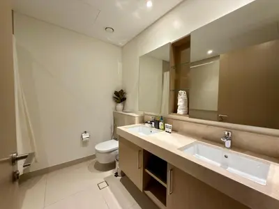 a bathroom with two sinks and a toilet at Sunset Sea View at 5242 Emaar in Dubai