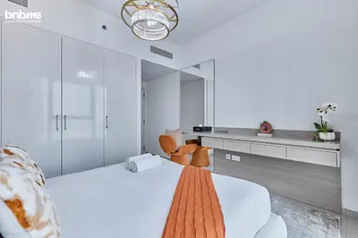 a bedroom with a white bed and a mirror at bnbmehomes - Downtown Views II in Dubai