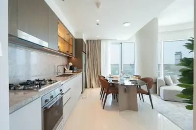 a kitchen with a table and a dining room with a couch at KeyRock - Palm & Sea View Retreat with Pool Access in Dubai