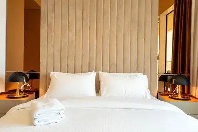 a bedroom with a white bed with two lamps at KeyRock - Palm & Sea View Retreat with Pool Access in Dubai