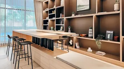 a kitchen with a bar with stools in it at Beautiful Brand New Studio -Pool -Balcony -Parking in Dubai
