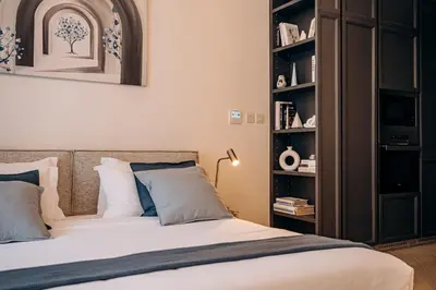a bedroom with a bed and a book shelf at Beautiful Brand New Studio -Pool -Balcony -Parking in Dubai