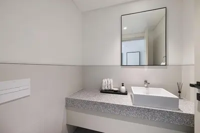 a white bathroom with a sink and a mirror at Luxury 3BR Palm Views at Emaar Beachfront in Dubai