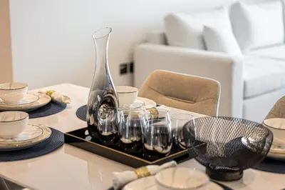 a table with glasses and a vase on a table at Luxury 3BR Palm Views at Emaar Beachfront in Dubai
