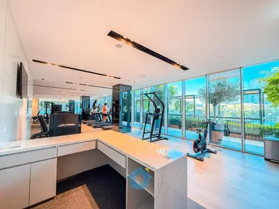 an office with a gym with a desk and windows at Next to Burj Khalifa & Dubai Mall - Luxury 2BR with Dubai Skyline Views - Like Home in Dubai