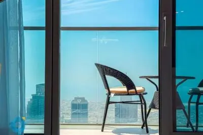 a chair on a balcony with a view of the city at Next to Burj Khalifa & Dubai Mall - Luxury 2BR with Dubai Skyline Views - Like Home in Dubai