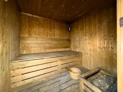 an empty wooden sauna with a bucket in it at GuestReady - High Floor | Canal View Near Dubai Marina in Dubai