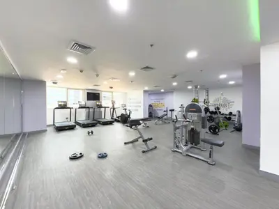 a gym with several treadmills and machines in a room at GuestReady - High Floor | Canal View Near Dubai Marina in Dubai