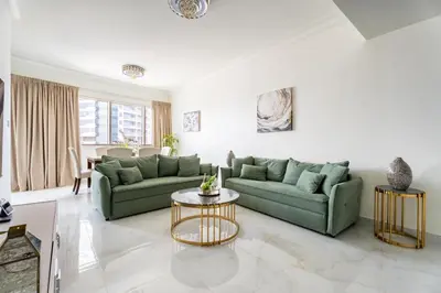 a living room with two green couches and a table at GuestReady - High Floor | Canal View Near Dubai Marina in Dubai