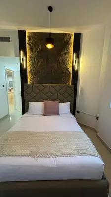 a bedroom with a large white bed with a stone wall at Best location in Marina & jbr and marina view 1 minute from JBR in Dubai
