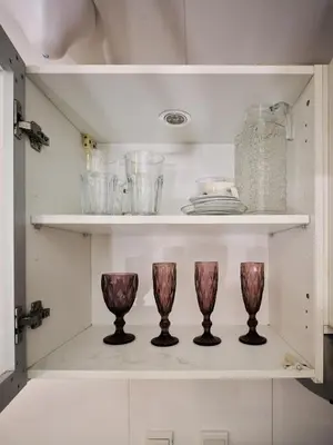 a shelf with three wine glasses and plates on it at Best location in Marina & jbr and marina view 1 minute from JBR in Dubai