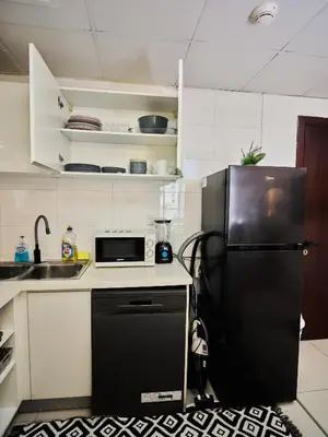 a kitchen with a black refrigerator and a sink at Best location in Marina & jbr and marina view 1 minute from JBR in Dubai