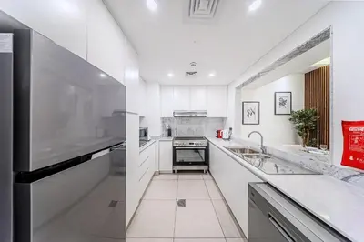 a kitchen with white cabinets and a counter top at Chic 2BD in Lamtara for 4, Madinat Jumeirah Living in Dubai