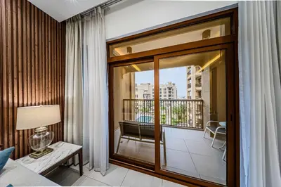 a room with a balcony with a bed and a window at Chic 2BD in Lamtara for 4, Madinat Jumeirah Living in Dubai