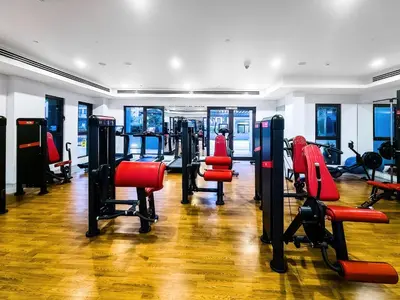 a gym with cardio equipment and red chairs at Chic 2BD in Lamtara for 4, Madinat Jumeirah Living in Dubai