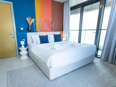 a large white bed in a room with a colorful wall at Palm Mirage Holiday Homes-2BR With Burj Alarab and City view in Dubai