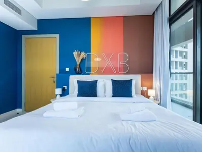 a bedroom with a large bed with a colorful wall at Palm Mirage Holiday Homes-2BR With Burj Alarab and City view in Dubai