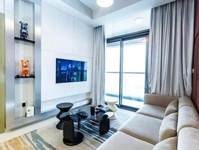 a living room with a couch and a tv at Palm Mirage Holiday Homes-2BR With Burj Alarab and City view in Dubai