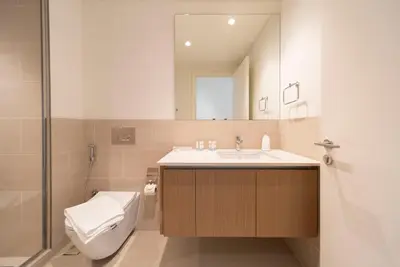 a bathroom with a sink and a toilet and a mirror at Ultra Luxuary 2BR - Creek Beach - Serenity Living in Dubai
