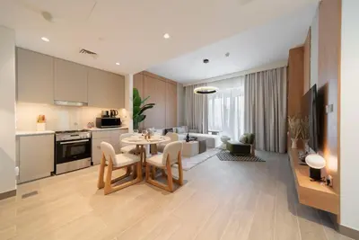 a kitchen and living room with a table and chairs at Ultra Luxuary 2BR - Creek Beach - Serenity Living in Dubai