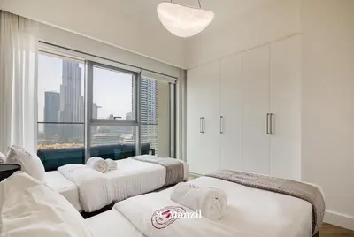 three beds in a room with a large window at Luxury 2BR Apartment in Downtown with Full Burj Khalifa View in Dubai